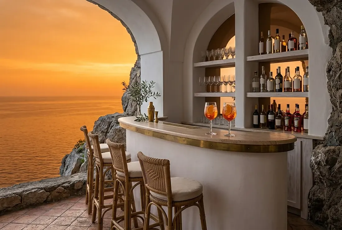 Cliffside cocktail bar at sunset with rattan stools